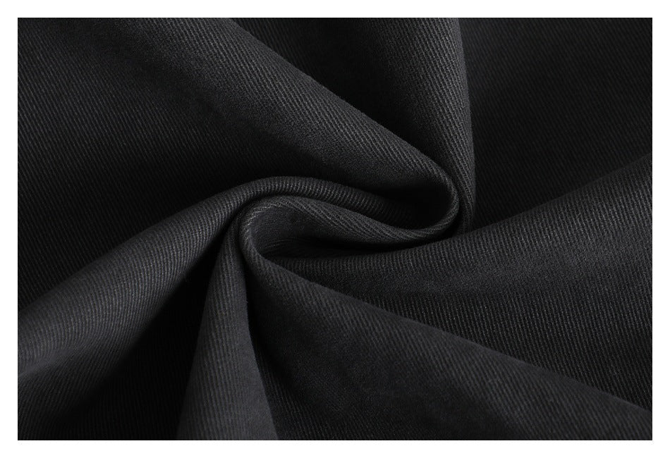 Close-up of dark twill fabric draped in soft folds.