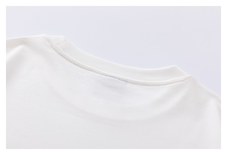 Close-up of a white shirt's ribbed crew neckline and shoulder seam.