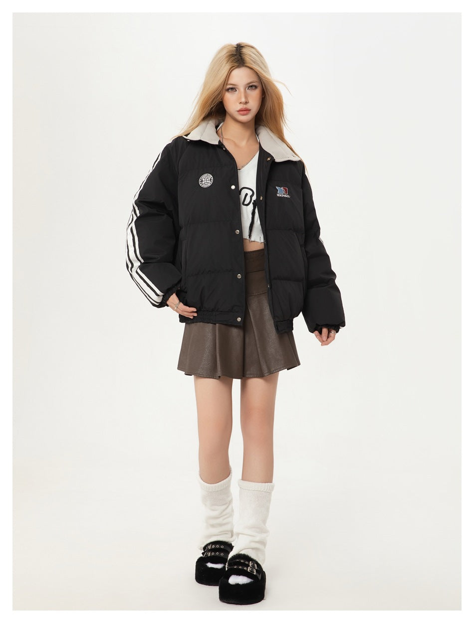 Model wearing black puffer jacket open over a white crop top and brown mini skirt, showing striped sleeves