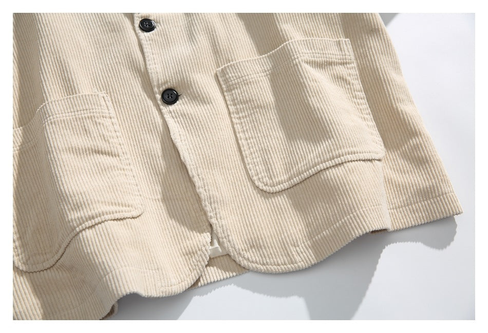 Close-up of the cream jacket front showing dark buttons and two large patch pockets.