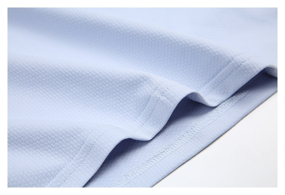 Close-up of pale blue textured knit fabric with a folded, stitched hem.