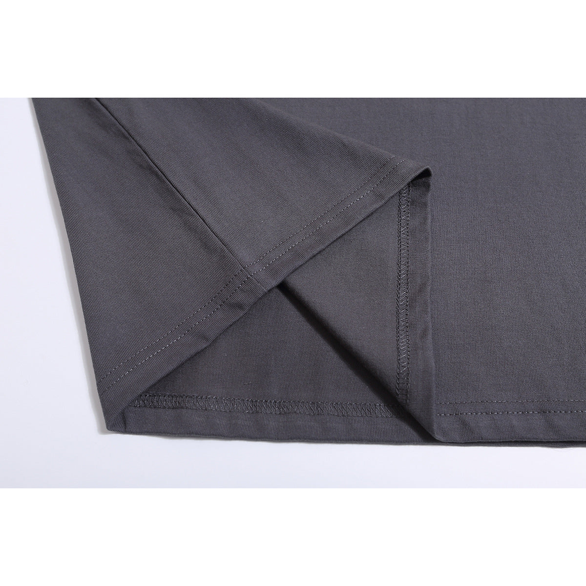 Close-up of a charcoal-gray T-shirt sleeve and interior overlock stitching.