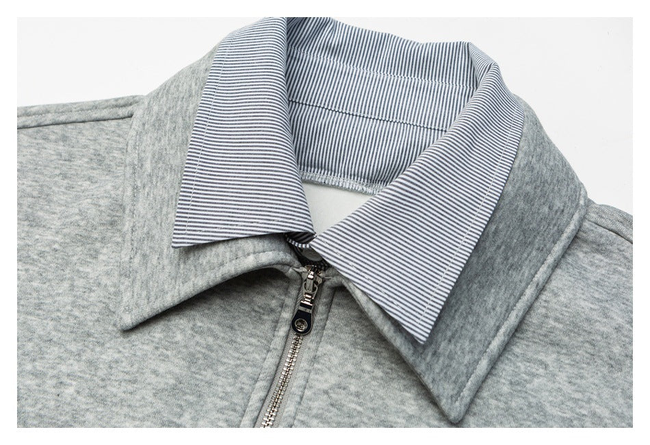 Close-up of the gray pullover's blue-and-white striped collar lining and front zipper.