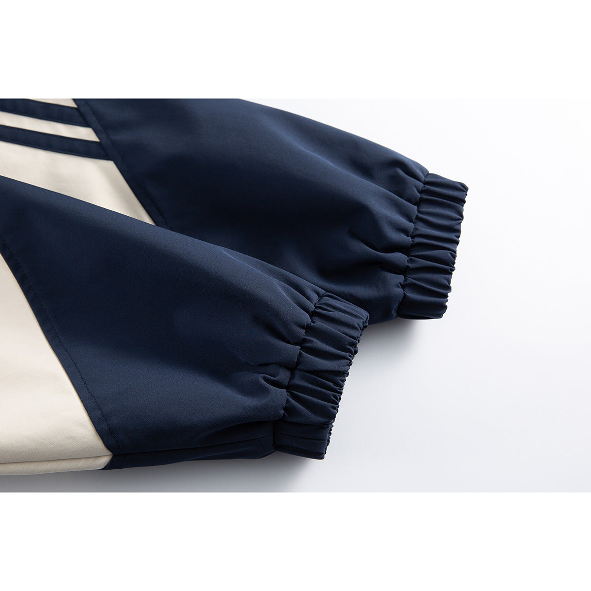 Close-up of the jacket's navy sleeves with gathered elastic cuffs and cream color-block panels.