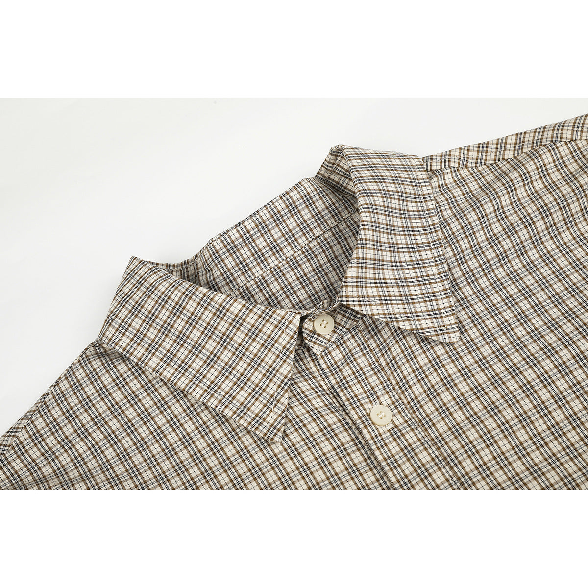 Close-up of a beige, brown, and black plaid shirt collar and upper button placket.