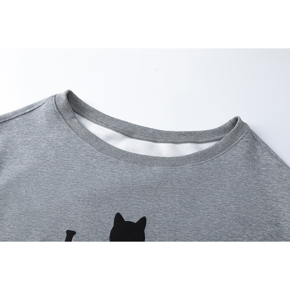 Close-up of a gray sweatshirt's ribbed crew neck and partial black cat graphic.