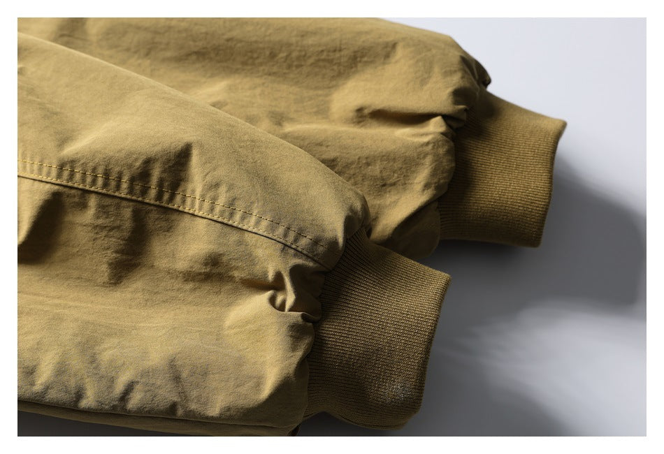 Close-up of a tan jacket's gathered sleeves and ribbed cuffs.