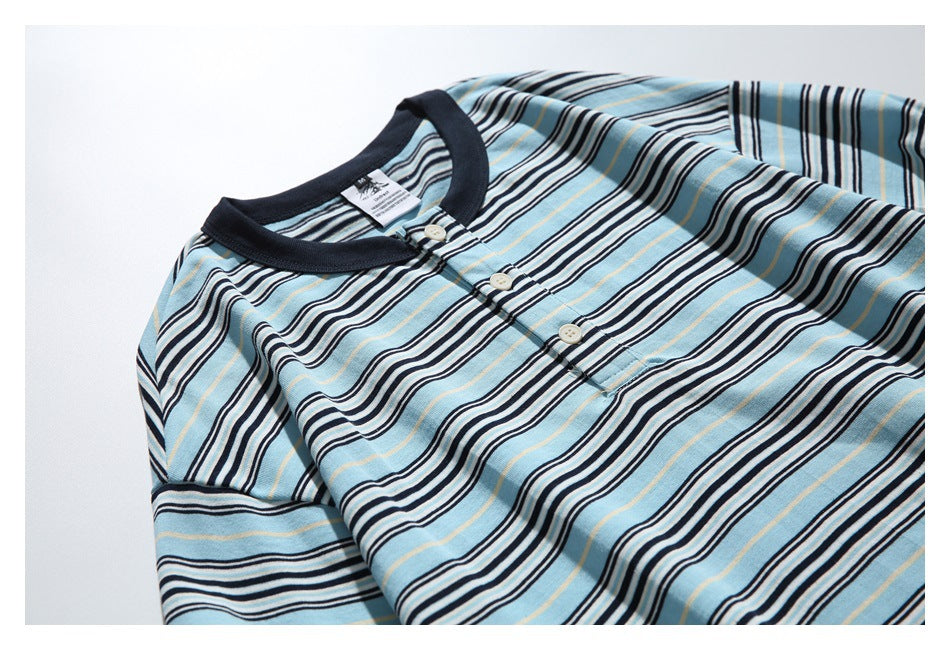 Angled flat-lay of a striped light blue shirt with a dark ribbed collar and short three-button placket.