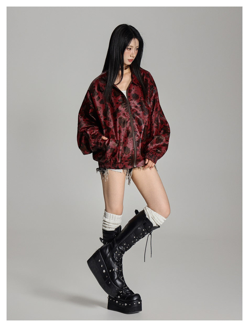 Model in a burgundy-and-black printed zip jacket, shown in a full-length three-quarter pose.
