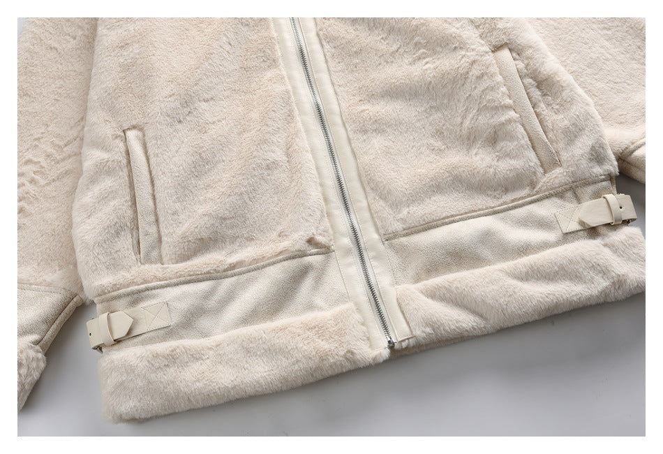 Close-up of the ivory faux-fur jacket's lower front, showing zip pockets and adjustable buckle tabs at the hem.