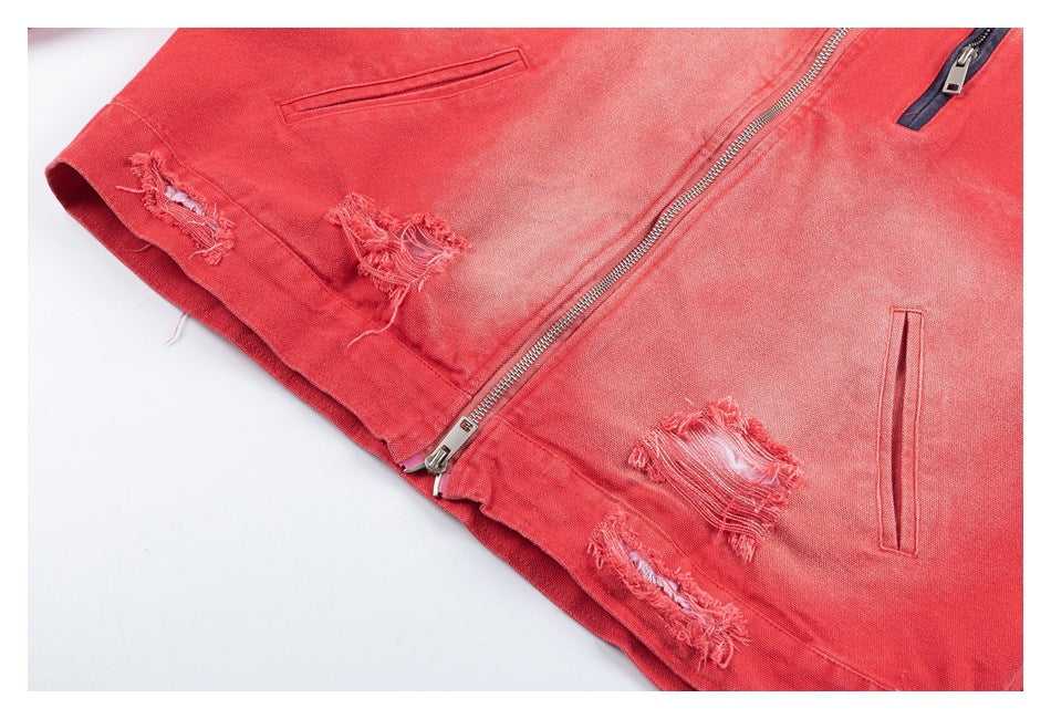 Partial flat-lay view of a coral-red jacket with distressed patches, welt pockets, and a silver zipper.