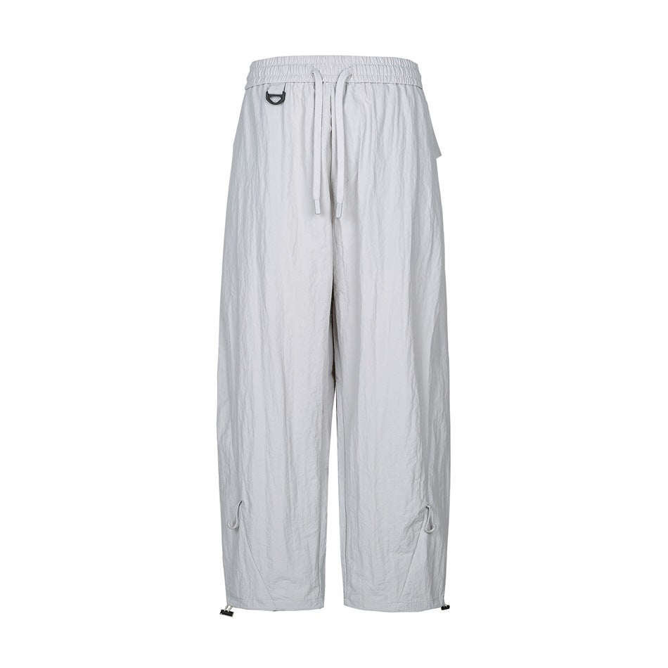 Light gray wide-leg drawstring pants with D-ring, flap pocket and toggle drawcord hems, front flat view