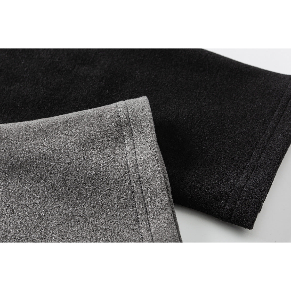 Close-up of gray and black long-sleeve shirt cuffs showing their fabric and stitched edges.