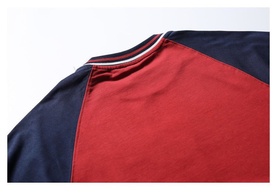 Close-up of the upper back of a red shirt with navy shoulder panels and a striped crew neckline.
