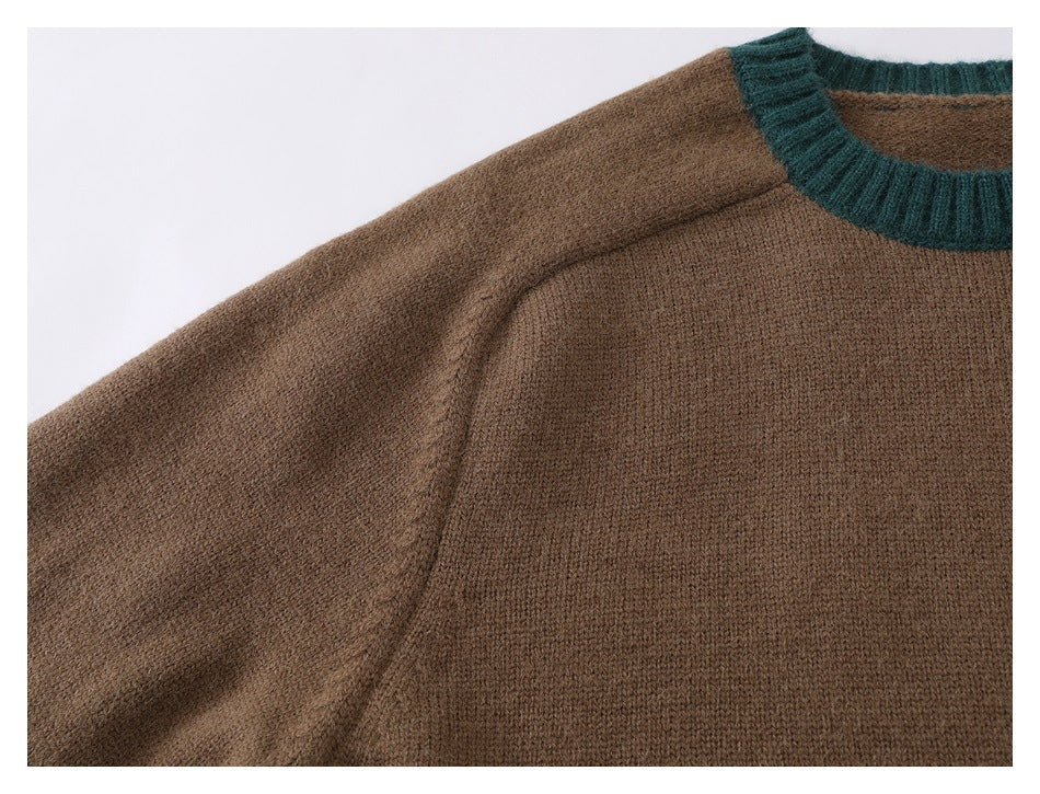 Close-up of the brown sweater's knit fabric, shoulder seam, sleeve, and dark teal neckline trim.