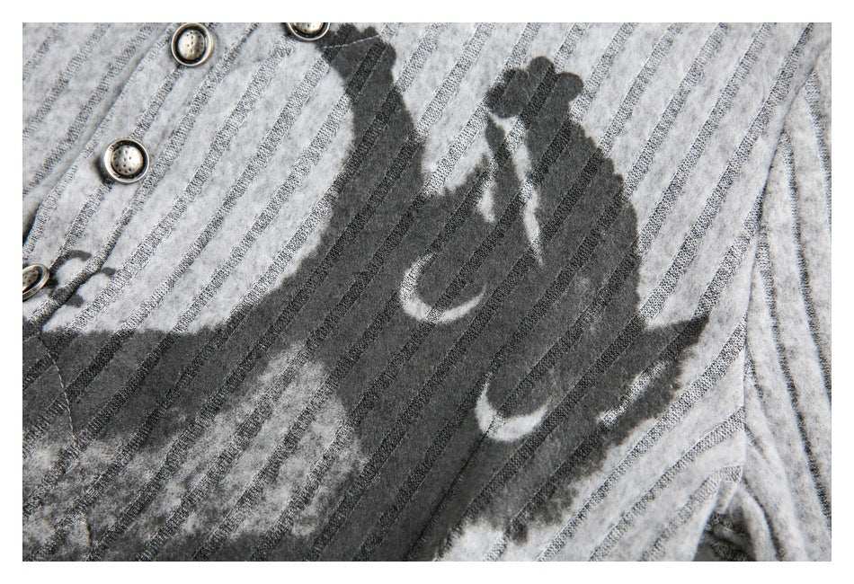 Close-up of dark graphic lettering and shapes printed over light gray stripes on a garment.