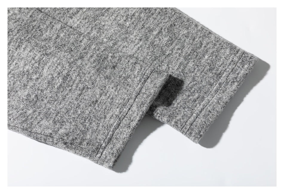 Close-up of heather gray textured fabric with a stitched edge on a white background.