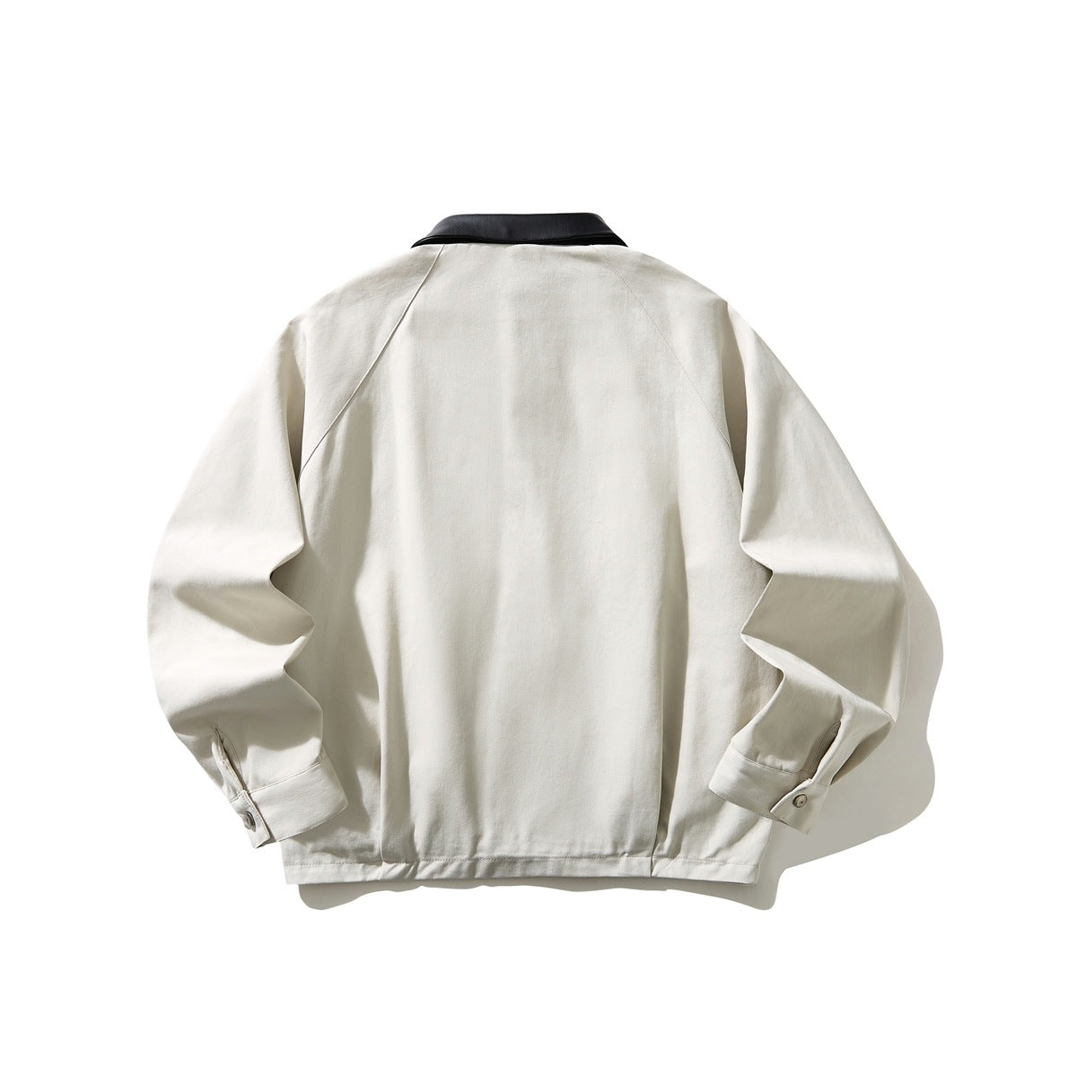 Back view of an ivory long-sleeved jacket with a black collar and buttoned cuffs.