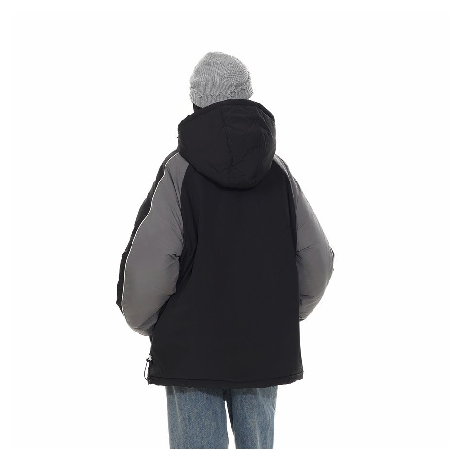Back view of a model wearing a black hooded jacket with gray sleeves and white piping.