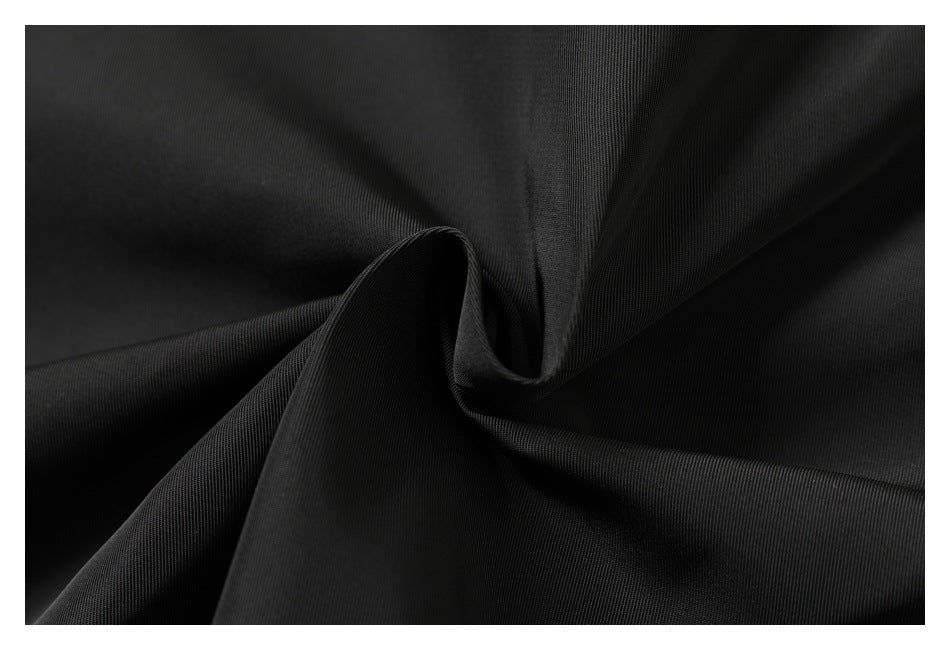 Close-up of black garment fabric gathered into soft folds.