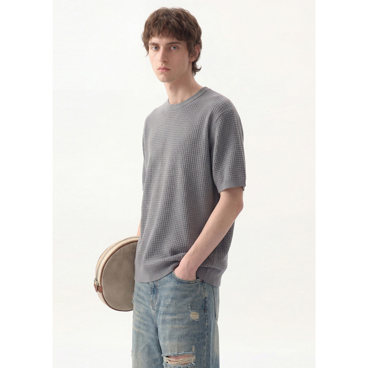 Model wearing a gray textured short-sleeve crew-neck shirt with light distressed jeans.