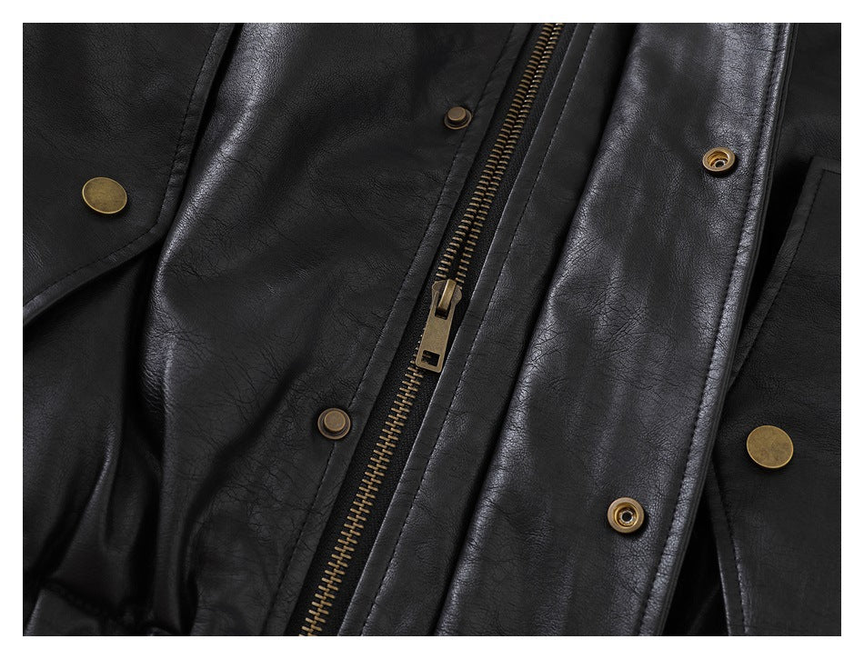 Close-up of a black jacket's front zipper, snap fasteners, and overlapping placket.