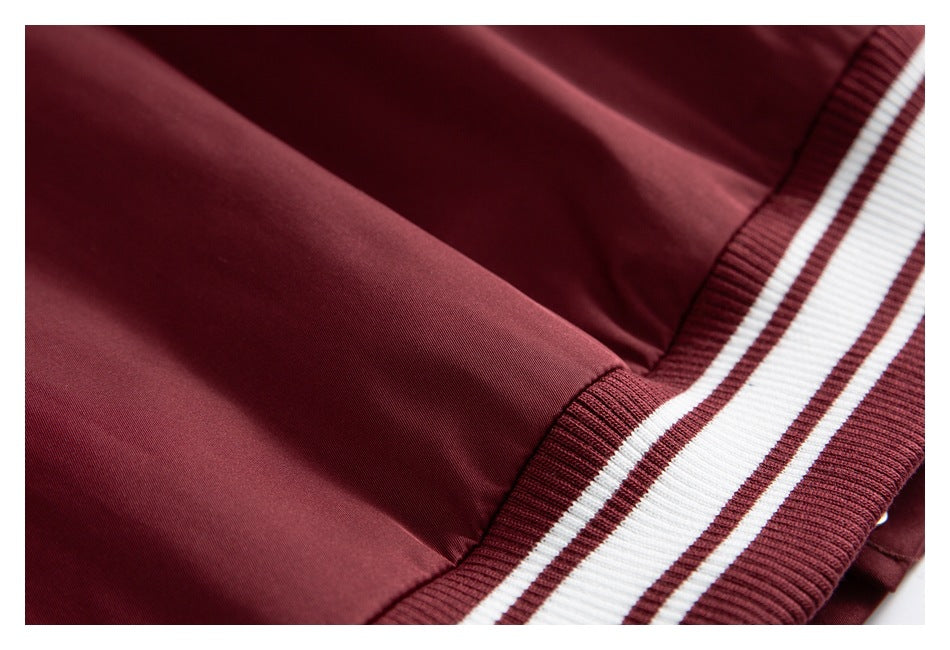 Close-up of burgundy jacket fabric and a ribbed burgundy-and-white striped band.