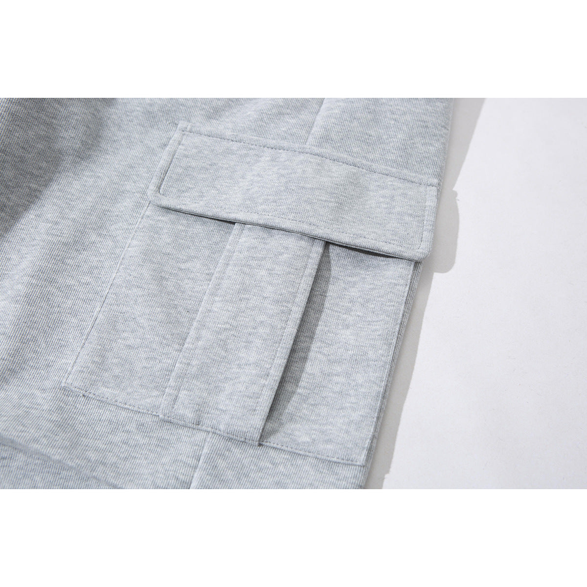 Close-up of a large flap cargo pocket on light gray pants.