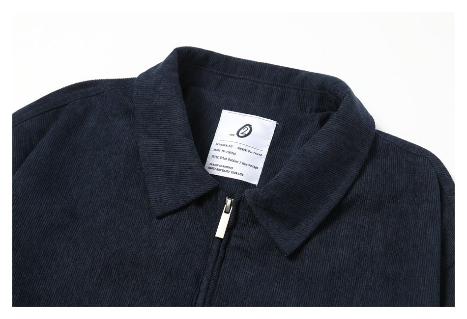 Close-up of a navy ribbed jacket collar, zipper, and interior label.