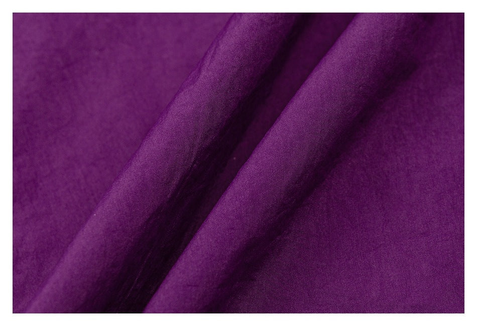 Close-up of purple fabric showing its surface texture and soft folds.
