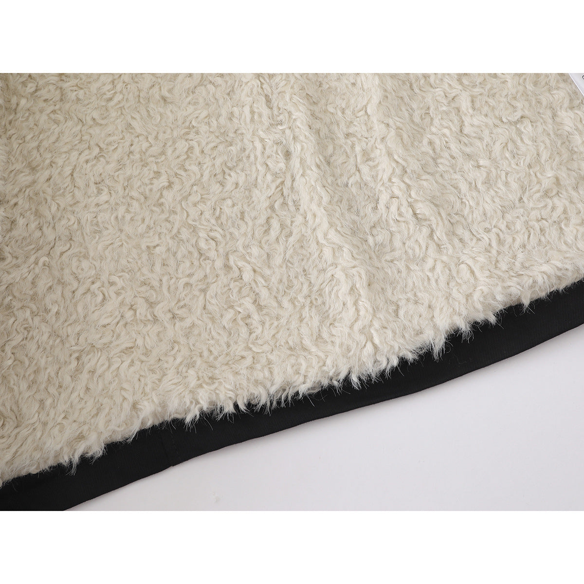 Close-up of the jacket's white fluffy lining beside its black outer edge.