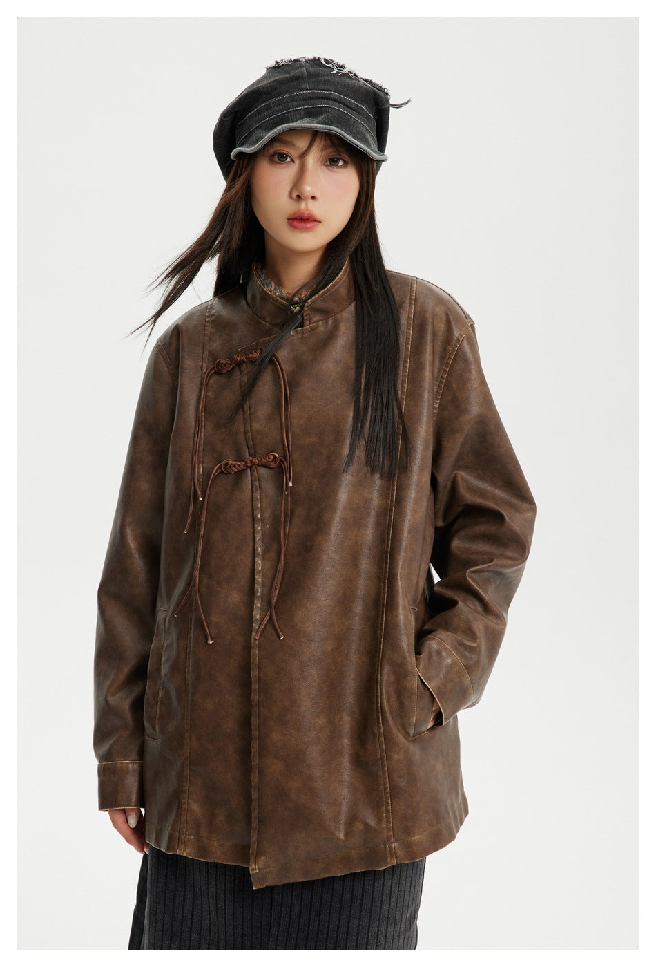 Model wearing a brown mottled-finish jacket with a high collar and braided tie closures, shown from the front.