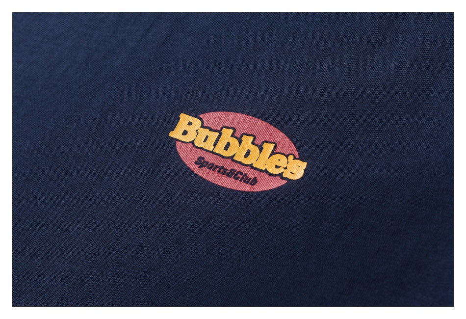 Close-up of a small yellow and red Bubble Sportsclub graphic printed on navy fabric.