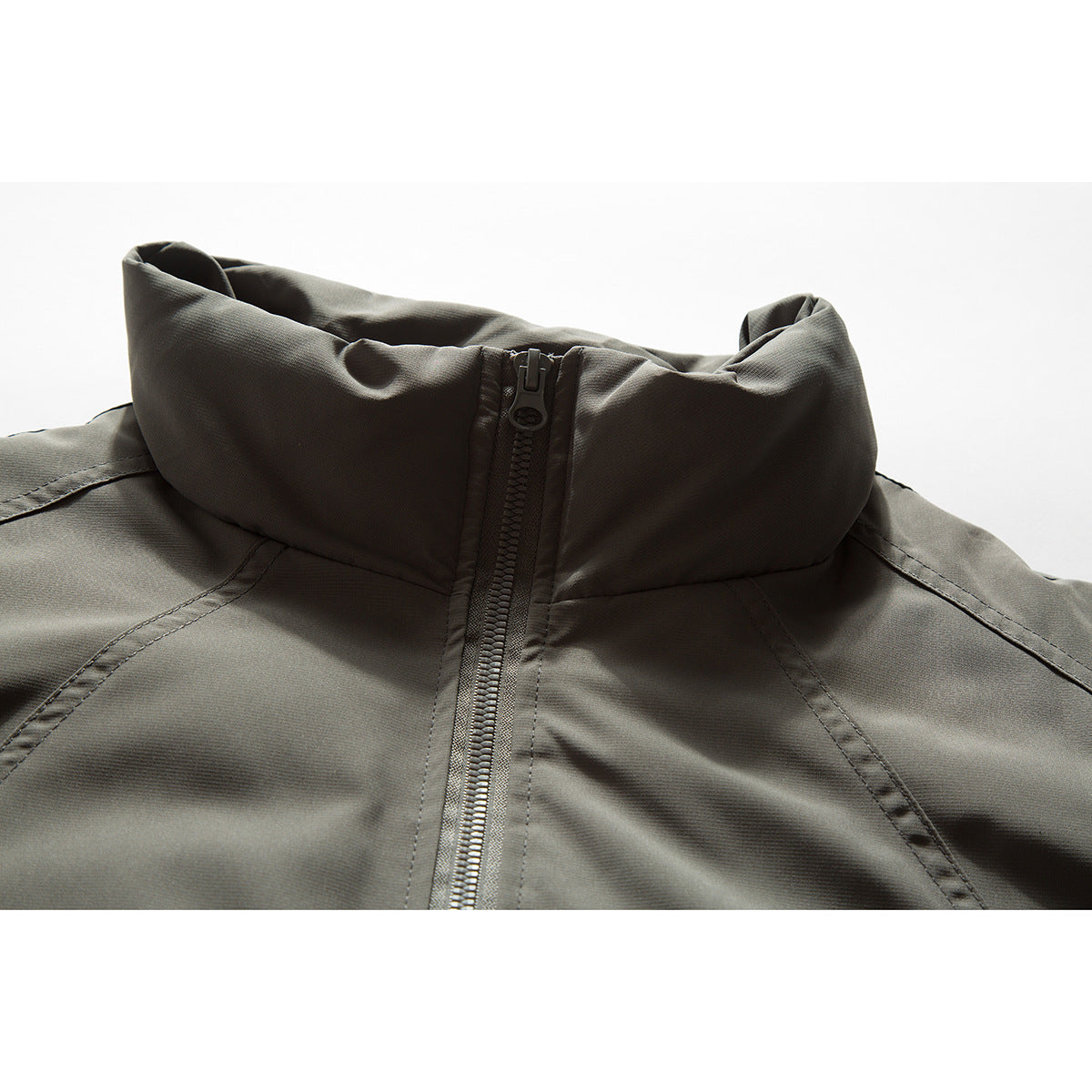 Close-up of a dark olive-gray jacket with a tall stand collar and central zipper.