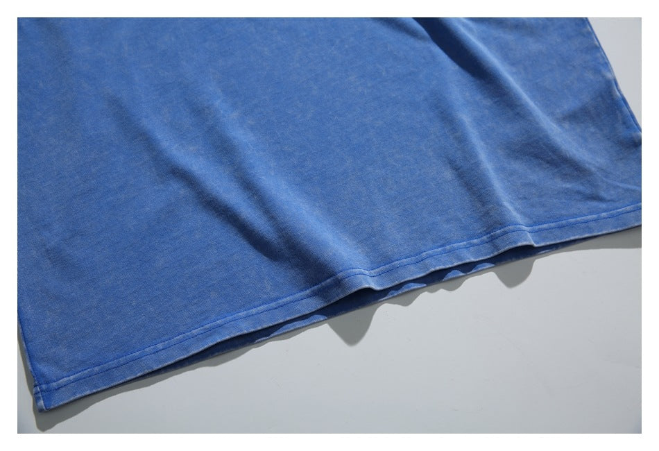Close-up of the plain blue T-shirt body and stitched bottom hem.
