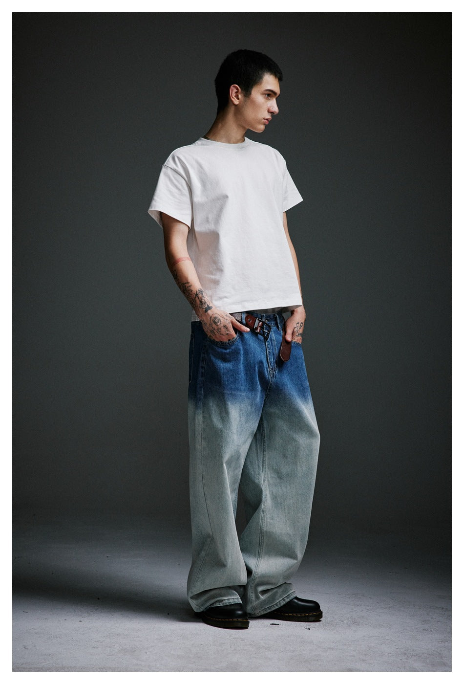 Side view of a model wearing a white T-shirt and very wide blue-to-pale-wash jeans.