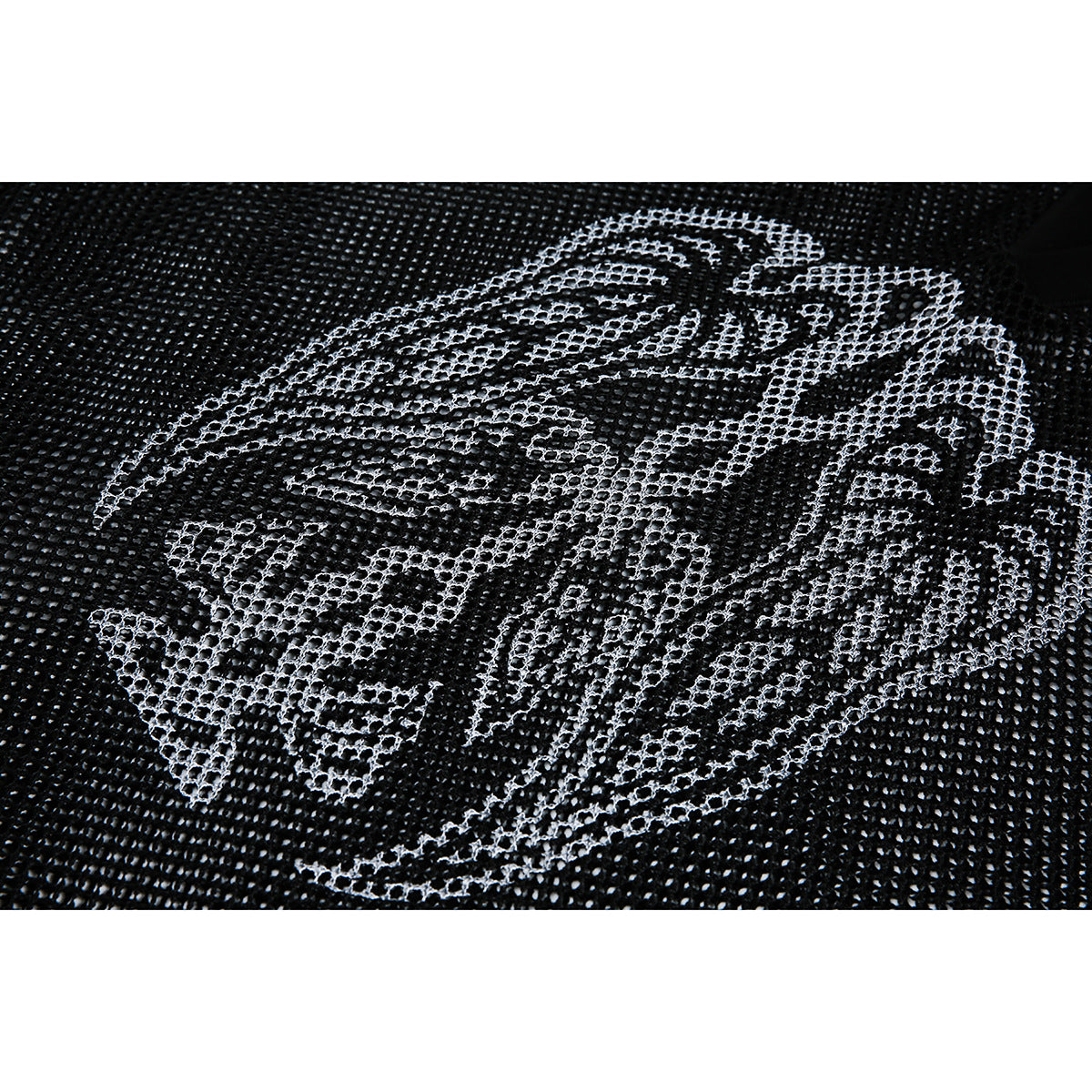 Close-up of a large pale abstract graphic printed across black open-knit fabric.