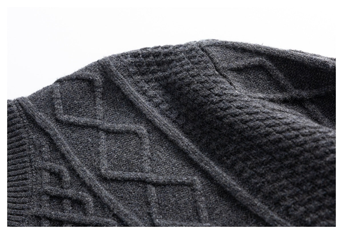 Close-up of the raised cable-knit pattern on a charcoal gray cardigan shoulder.
