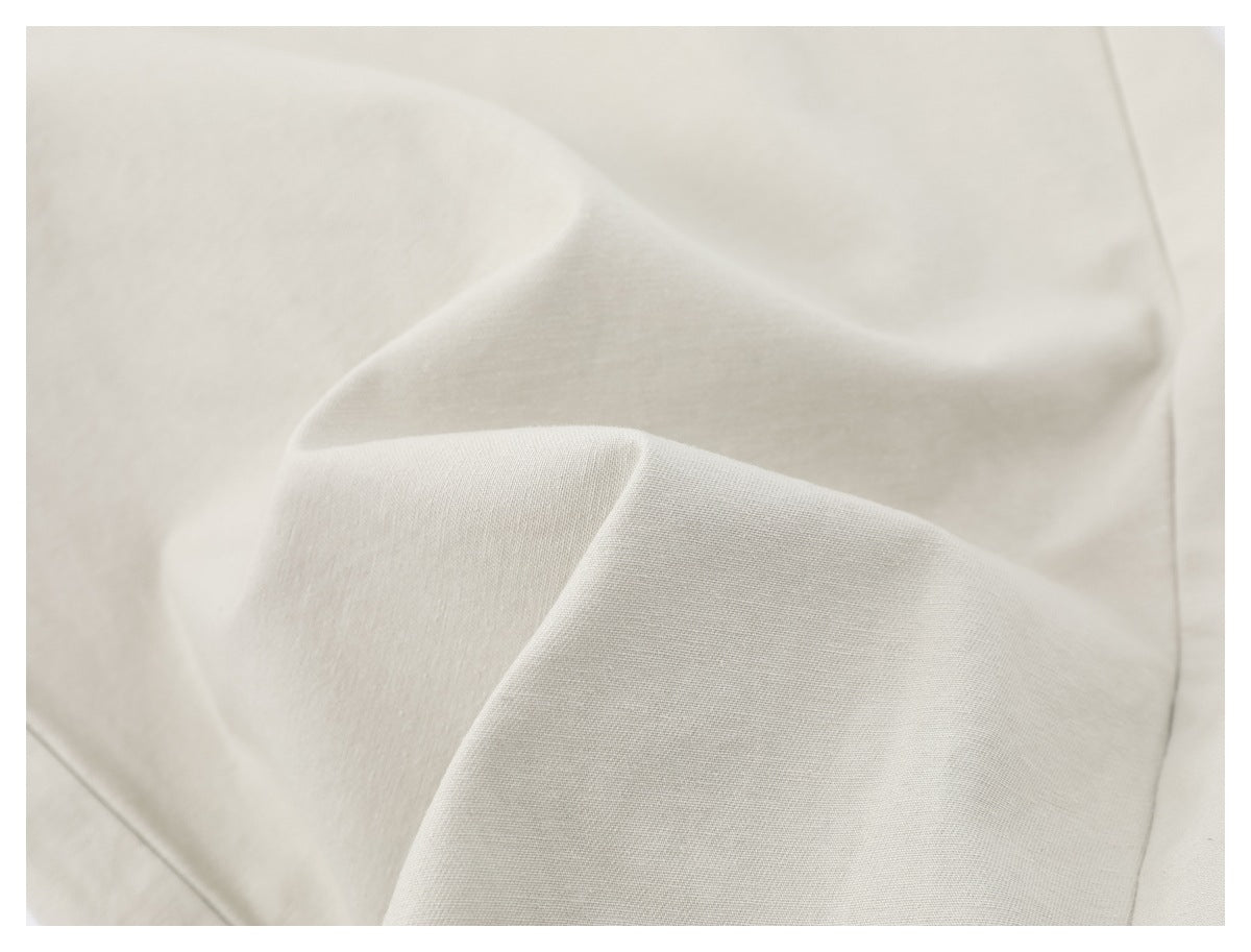 Close-up of pale ivory fabric with soft folds and a fine visible weave.