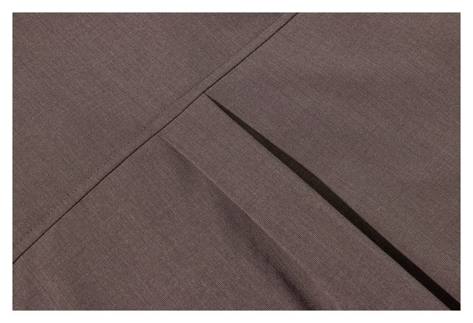 Close-up of taupe-brown garment fabric showing a seam and overlapping folded panel.