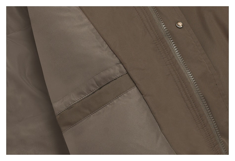Close-up of a brown jacket's front zipper, snap fastener, and stitched seam.