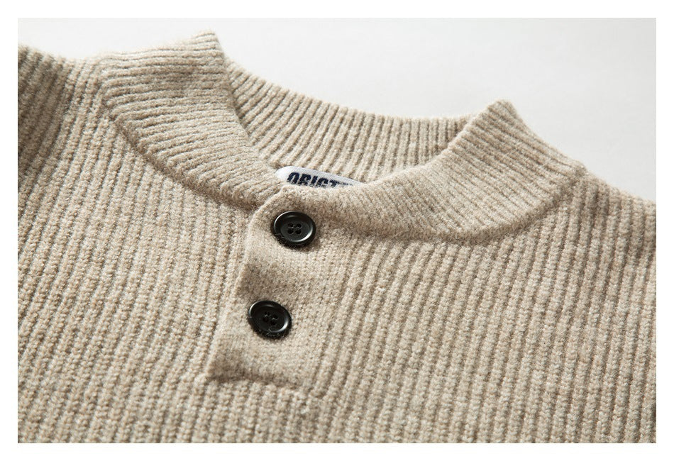 Close-up of a beige rib-knit sweater collar with two dark buttons and a small sewn-in neck label.