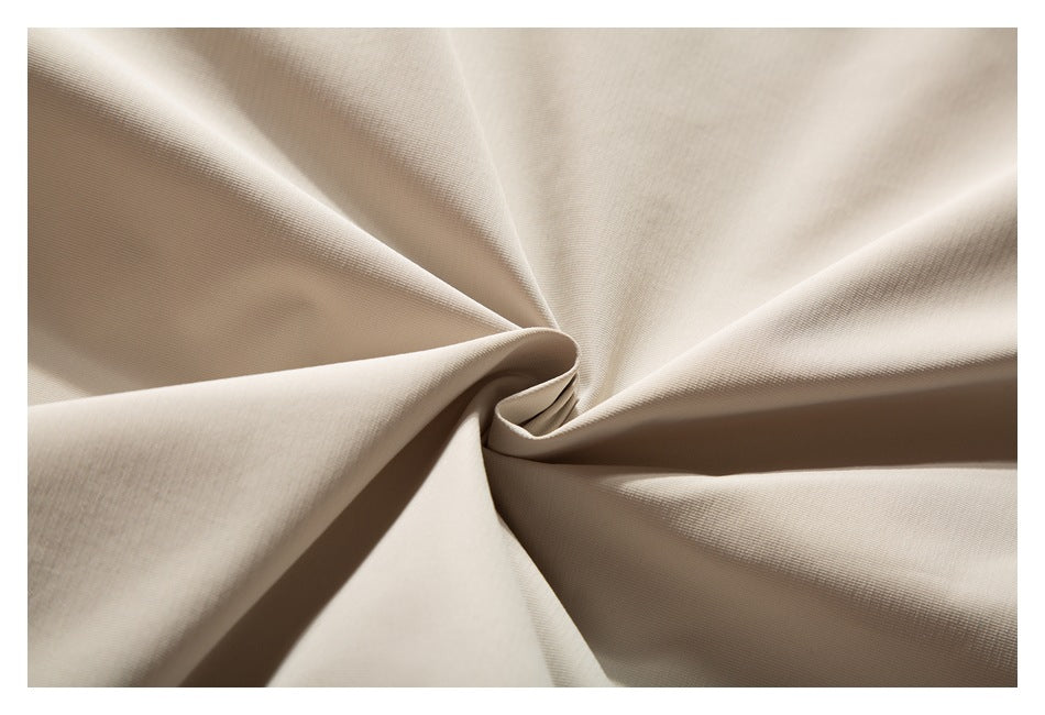 Close-up of beige garment fabric draped into soft folds.