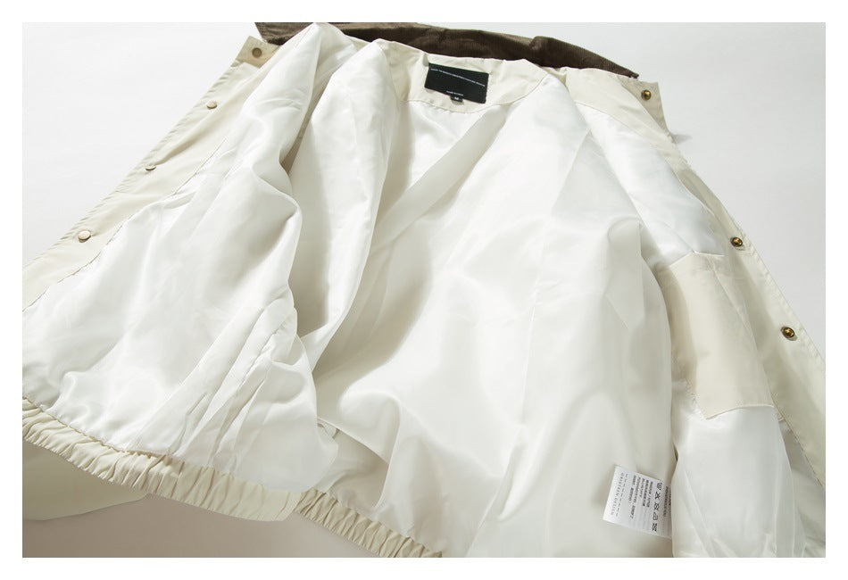 Inside view of an ivory jacket laid open, showing its pale lining, snap fasteners, collar, and care label.