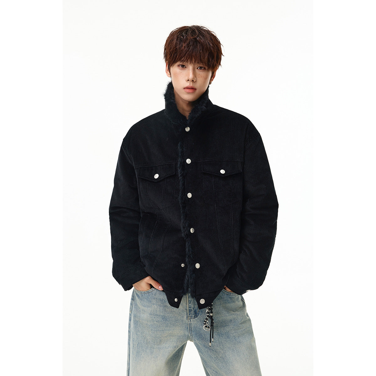 Model wearing a black ribbed jacket with a plush collar, snap buttons and two flap chest pockets.