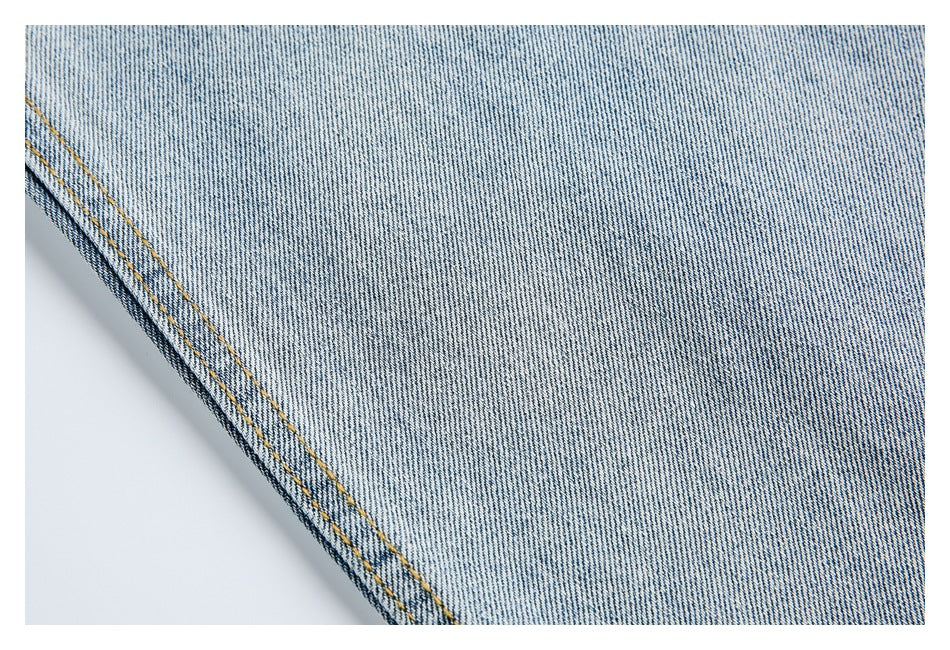 Close-up of light-wash denim leg fabric and double-stitched outer seam.