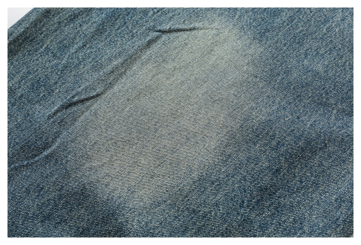 Close-up of blue denim fabric showing its diagonal weave and washed, faded texture.