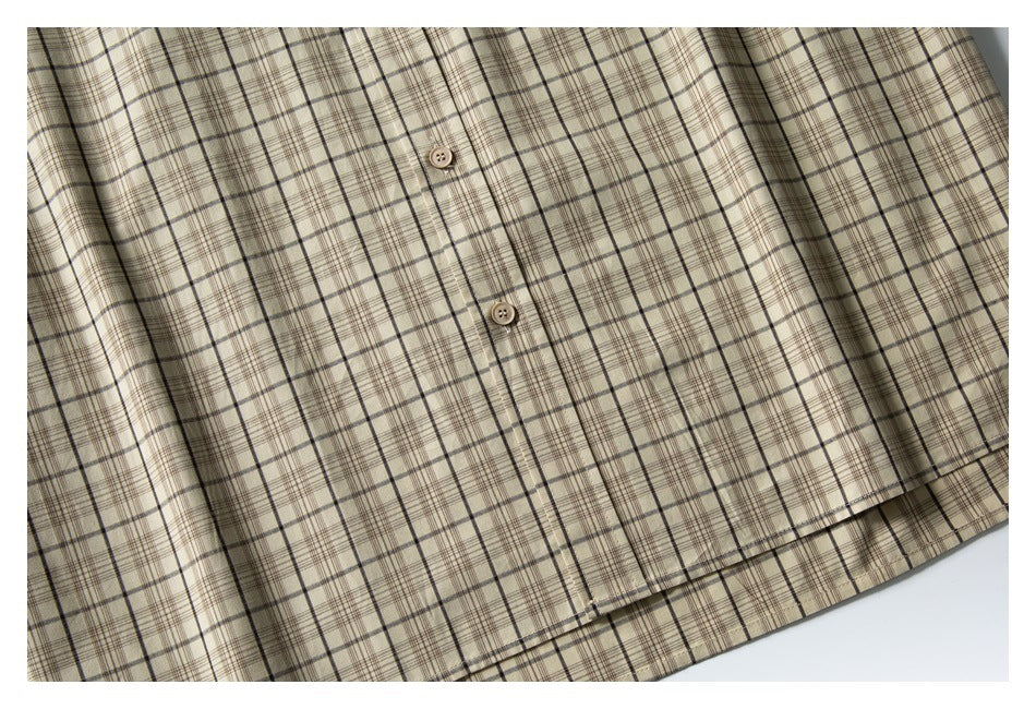 Close-up of the beige plaid shirt front, showing two buttons, placket, and hem.