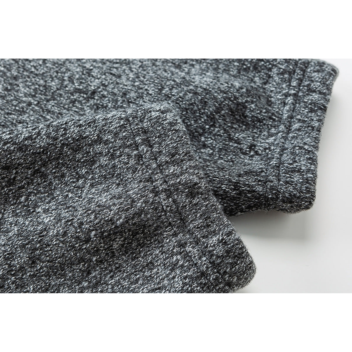 Close-up of the charcoal marled pullover's sleeve cuff and stitched seam.