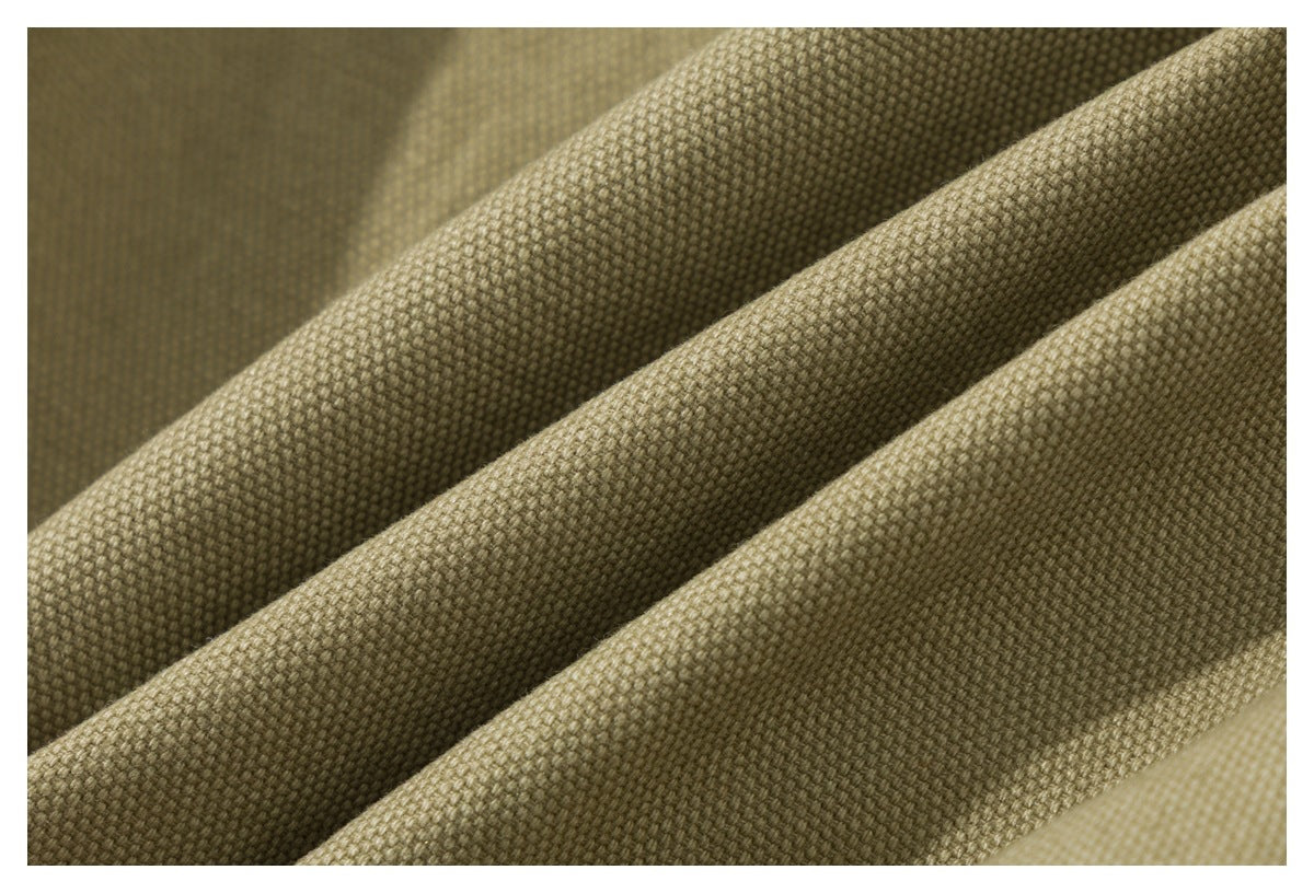 Macro view of olive-khaki woven fabric arranged in soft folds.